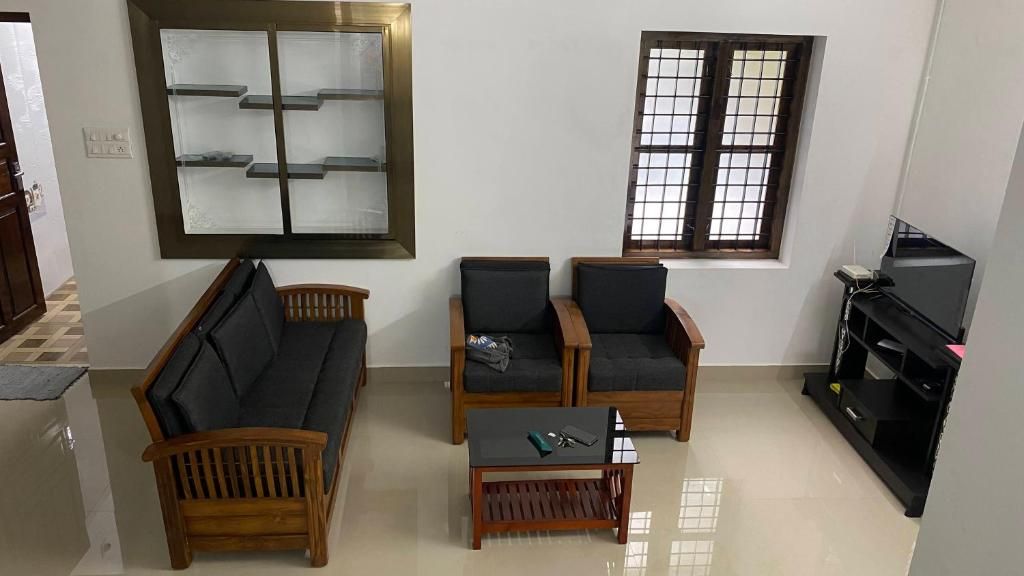 Living room with sofa, chairs and TV.