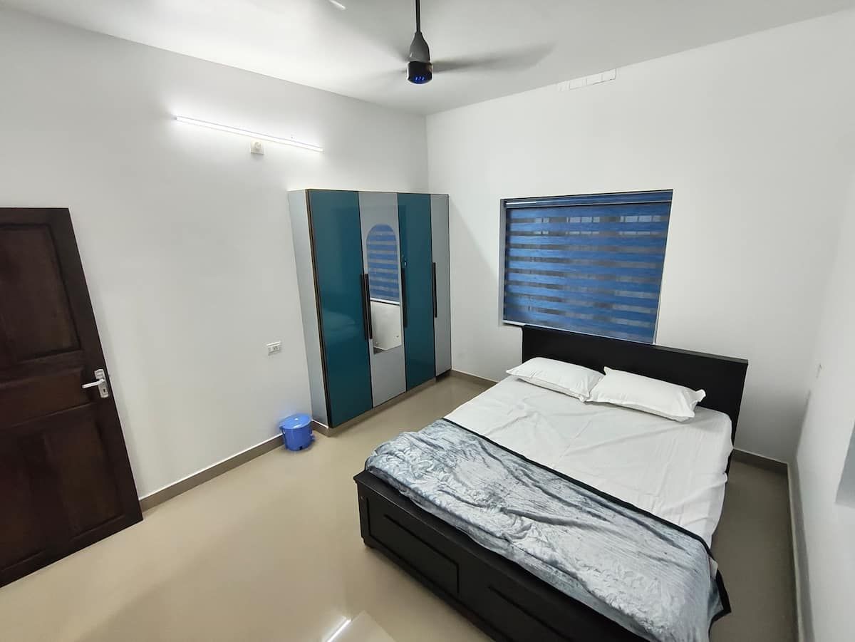Master bedroom with king bed, wardrobe and ceiling fan.